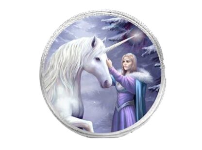A white unicorn stands with one leg raised in front of a blond woman who is wearing a purple dress and blue fur lined cloak. She is caressing the unicorn's face. The background is a blue, purple and white winter forest scene. The round purse is silver.