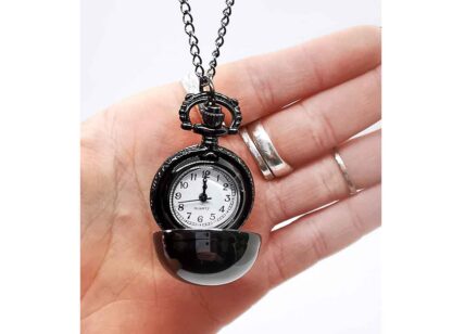 The fob watch open in a hand showing that it fits neatly in the palm due to its small size