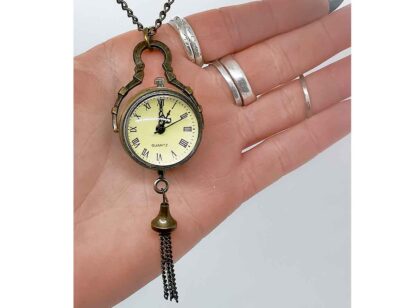 The fob watch in a hand showing its small size